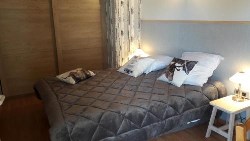 une chambre avec un grand lit avec deux oreillers dans l'établissement La grange des Blancs, à Mouxy