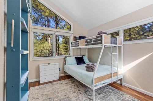 a bedroom with a bunk bed and two windows at The Golfview Getaway in Flagstaff