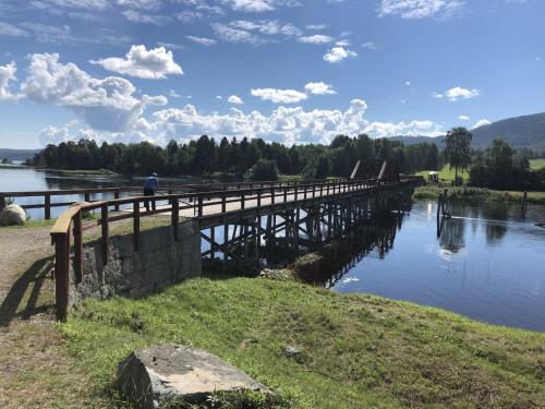 a man walking across a wooden bridge over a river at Apartment near the lake Gissjö, Fränsta in Fränsta