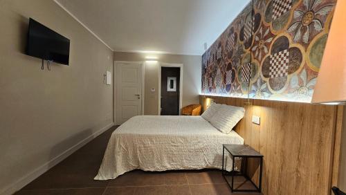 a bedroom with a bed and a painting on the wall at Antica Dimora Palazzo Ciprani in Anagni
