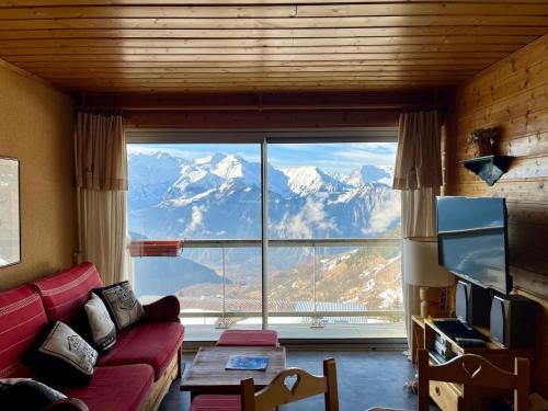 - un salon doté d'une grande fenêtre offrant une vue sur la montagne dans l'établissement T3 Plein Sud - Proche remontées mécaniques, à Huez