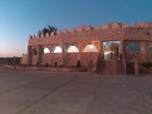 a brick building with arches and stairs in front at Oasis Panorama in Bawiti