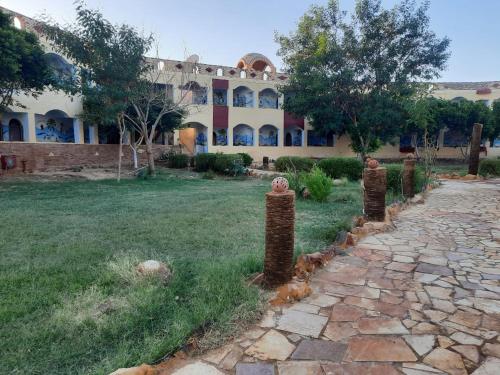 a building with a stone path in front of a yard at Oasis Panorama in Bawiti