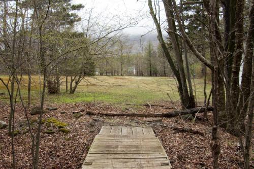 a wooden path in the middle of a forest at 1894 Catskills Farmhouse Retreat in Tannersville