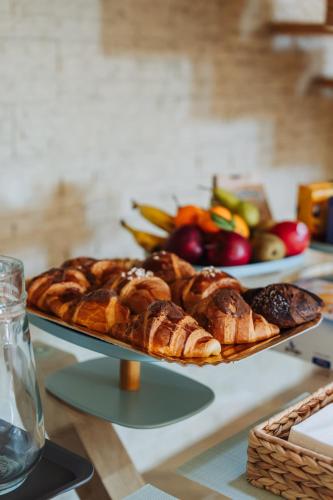 een dienblad met zoete deegwaren en fruit op een tafel bij NOMA LUXURY BeB in Aversa