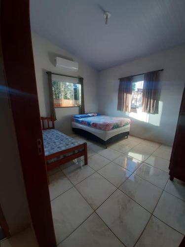 a bedroom with two beds and two windows at Casa MTB in Pirenópolis
