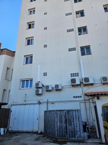 a white building with a gate in front of it at hotel Victoria in Perpignan