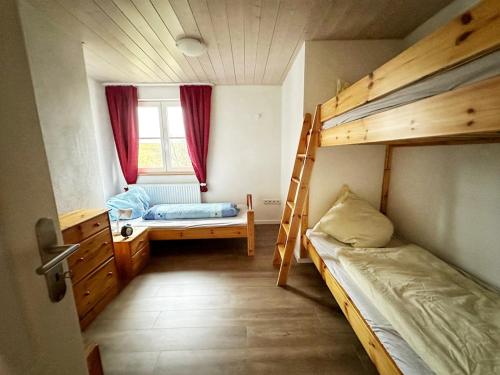 Un dormitorio con dos literas y una ventana. en Landhof Riehlingshöhe, en Kisslegg