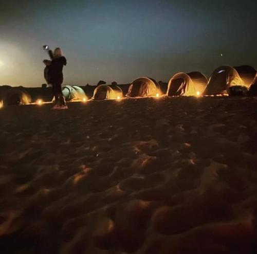 a group of tents on the beach at night at Oasis Panorama in Bawiti