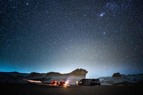 a group of tents under a starry sky at night at Oasis Panorama in Bawiti