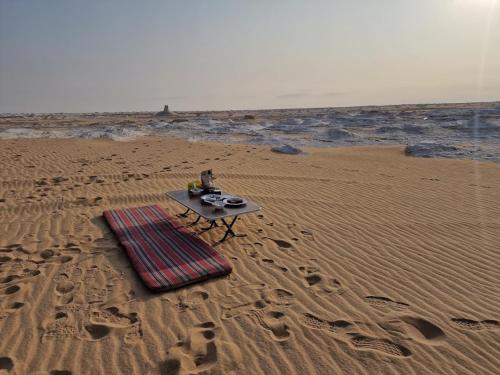 a table sitting on the beach with a plate on it at Oasis Panorama in Bawiti