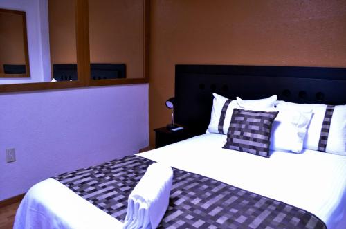 a bedroom with two beds with white sheets and pillows at Casa Green in Puebla