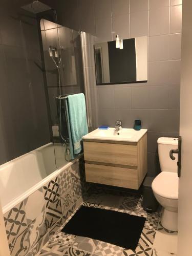 une salle de bain avec un lavabo, une baignoire et des toilettes dans l'établissement Agréable Studio, à Aurillac