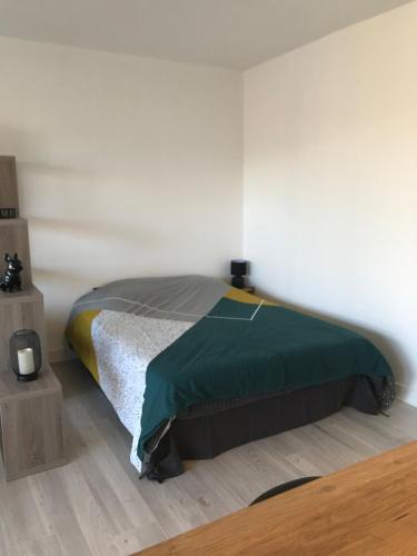une chambre avec un lit dans une pièce blanche dans l'établissement Agréable Studio, à Aurillac