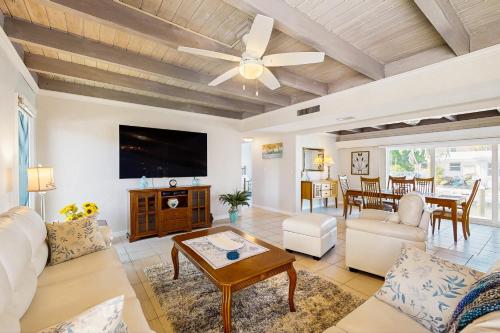 a living room with a ceiling fan and a tv at Serenity in Longboat Key