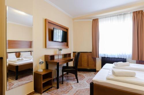 ブダペストにあるRichter Pansionのベッド2台とデスクが備わるホテルルームです。