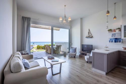 a white living room with a view of the ocean at White Pearl in Hanioti