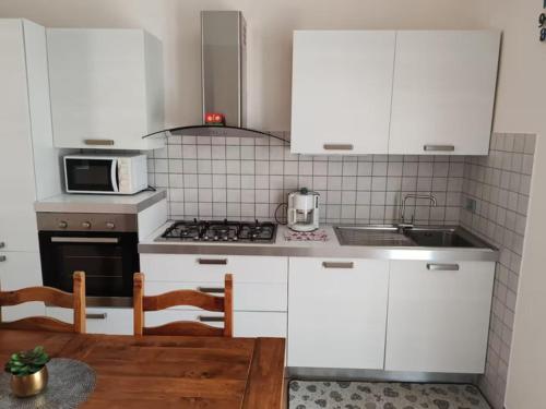 a kitchen with white cabinets and a stove top oven at "Casa Parletto" - Villa Esclusiva con Piscina in Caldana