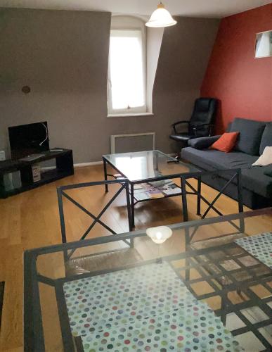 un salon avec une table en verre et un canapé dans l'établissement Le chardon lorrain, à Nancy