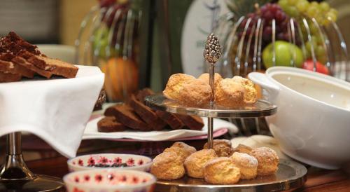a table with two tiers of pastries and other desserts at Arbutus Hotel in Killarney