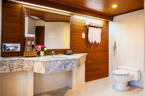 a bathroom with a sink and a toilet and a mirror at Lotus Pang Suan Kaew Hotel in Chiang Mai