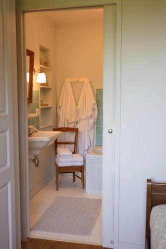 La salle de bains est pourvue d'un lavabo, de toilettes et d'une chaise. dans l'établissement La Foutelaie, à Clefs