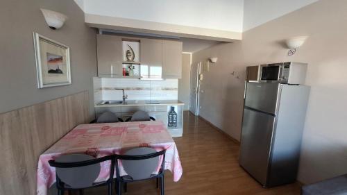 a small kitchen with a table and a refrigerator at Apartments Kimm's Hideaway in Poreč