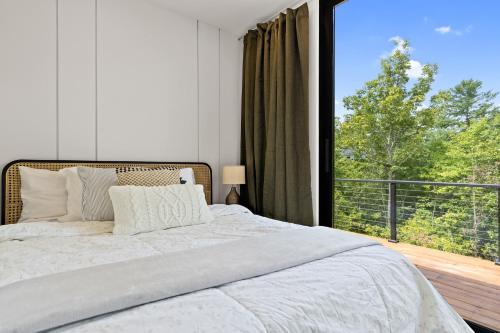 a bedroom with a bed and a large window at Luxury Container Hammock, Fire Pit Pool in Young Harris