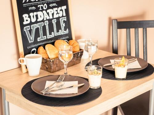 a table with two plates of food and a basket of bread at Budapest Ville Bed & Breakfast in Budapest