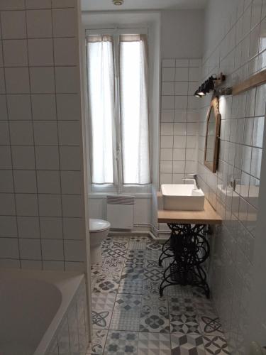 a bathroom with a sink and a toilet and a tub at La petite Parenthèse in Hauterives
