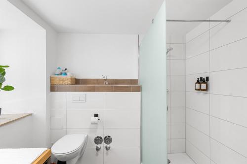 a white bathroom with a shower and a toilet at Ferienwohnung Goltan - Zentral - Küche - WIFI in Abensberg