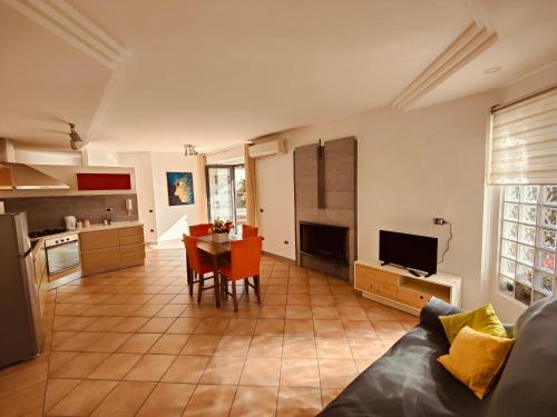 a large living room with a table and a kitchen at Maison Margot - Giardino e parcheggio privato in Volla