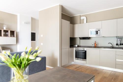a kitchen with white cabinets and a table at Green Living with Terrace & Garage by NDP rent in Milan