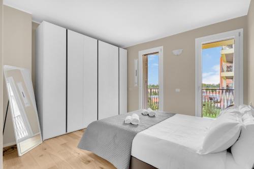 a white bedroom with a bed and a balcony at Green Living with Terrace & Garage by NDP rent in Milan