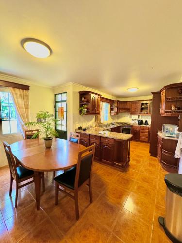 a large kitchen with a wooden table and chairs at The Sun Edge House in Ponta do Sol