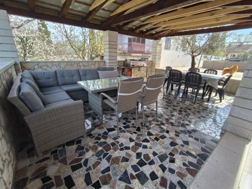a patio with a couch and chairs and a table at Apartments Kimm's Hideaway in Poreč
