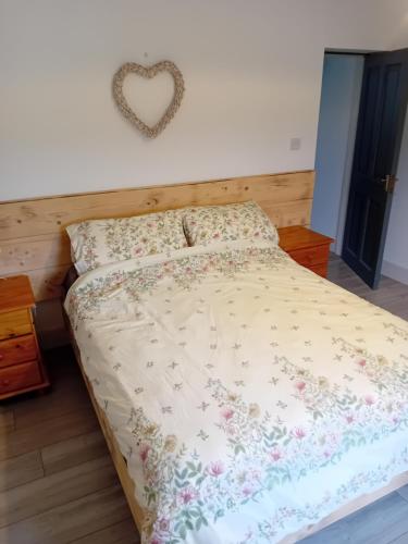 a bed in a bedroom with a heart on the wall at The Hideaway Tragumna a hidden gem in the hills in Drishanebeg