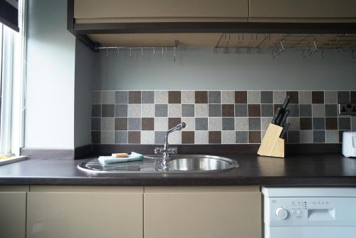 a kitchen counter with a sink in a kitchen at Ravenswood House in Glenrothes