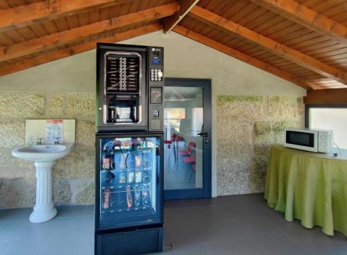 a vending machine with a microwave on top of it at Agroturismo Quinta De Travancela in Amarante