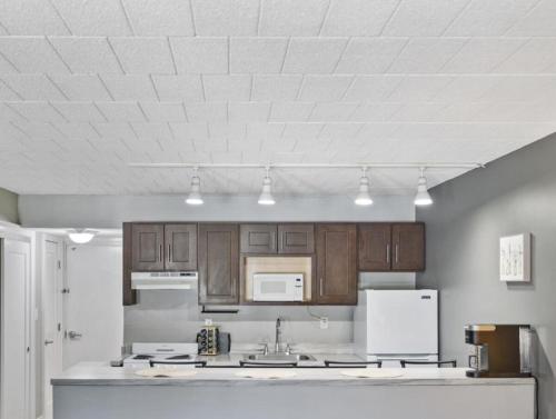 a kitchen with wooden cabinets and a white ceiling at The Luxe Nook, Premier Studio in Scenic Congers in Congers