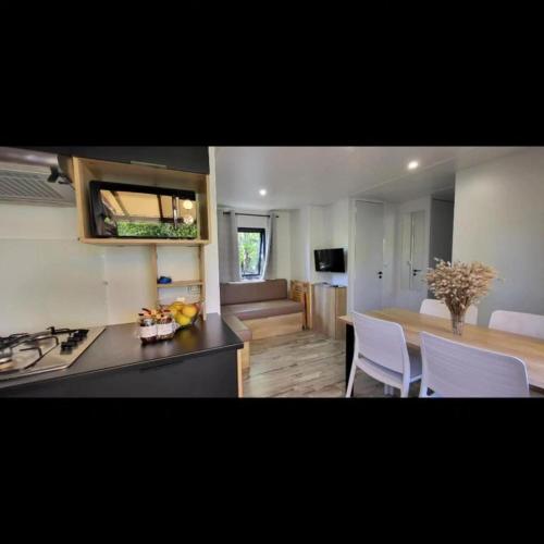 une cuisine avec un comptoir et une table avec des chaises dans l'établissement Mobil Home Premium 3 ch Camping 5 Biscarrosse Mayotte F63, à Biscarrosse