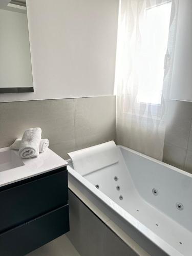 un bagno bianco con vasca e lavandino di Residence Dominic a Peschici