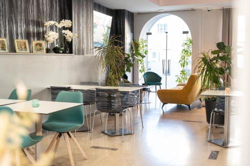 a restaurant with tables and chairs and plants at Grand Hôtel Niort Centre in Niort