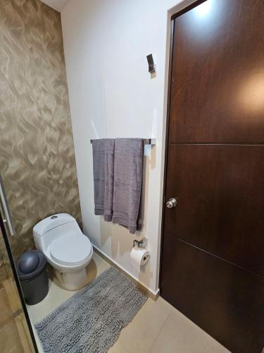 a bathroom with a toilet and a shower with towels at AC0 Casa de lujo en privada Altana in Culiacán