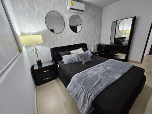 a bedroom with a bed and two mirrors on the wall at AC0 Casa de lujo en privada Altana in Culiacán