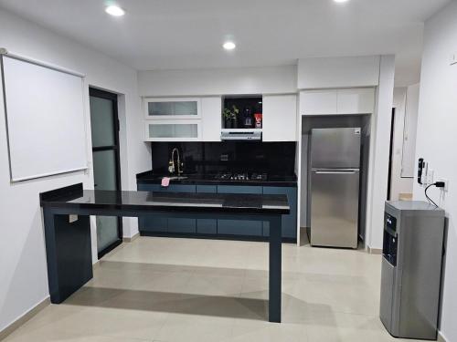 a kitchen with a black table and a refrigerator at AC0 Casa de lujo en privada Altana in Culiacán