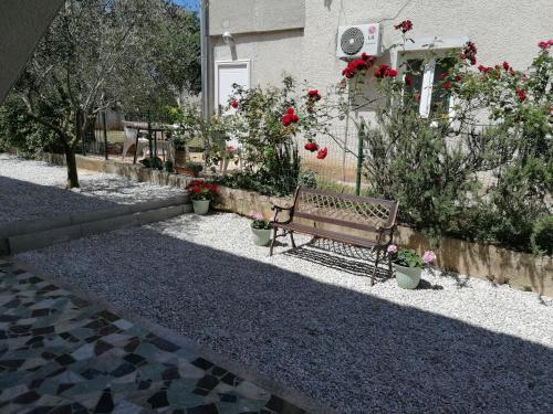 a bench sitting in front of a building with flowers at Apartments Kimm's Hideaway in Poreč