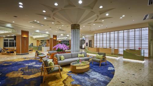 a lobby of a hotel with a couch and chairs at ANA Crowne Plaza Resort Okinawa Uruma Hills By IHG in Uruma