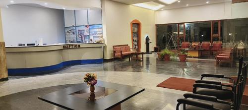 a lobby with a waiting area with a table and chairs at Hotel Shivasangam Residency in Bāgalkot