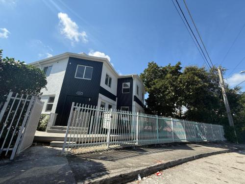 a blue house with a fence in front of it at Renzzi Villas in Miami